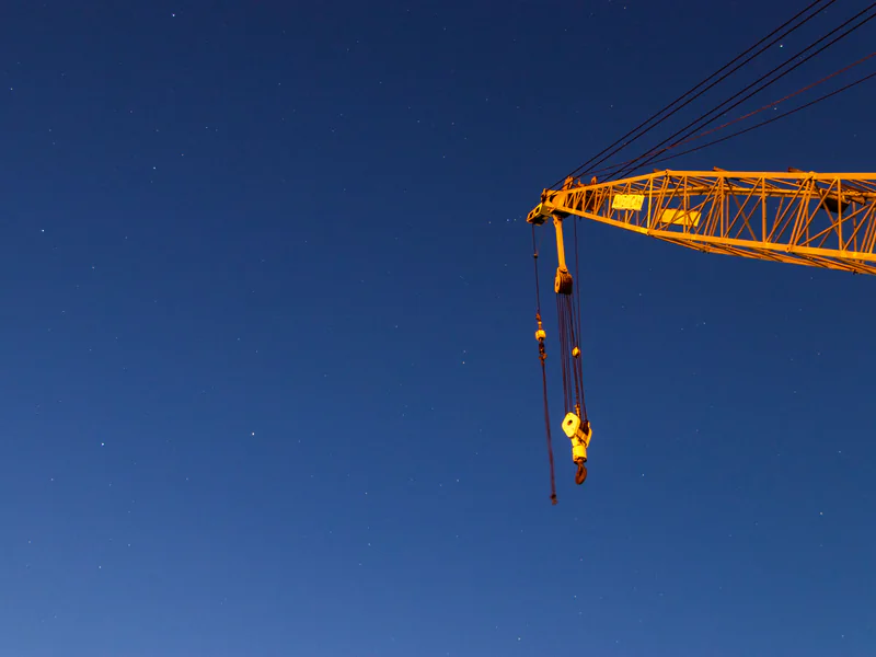 Industrial crane and suspended rigging illustrating attachment hardware and controlled lifting zones