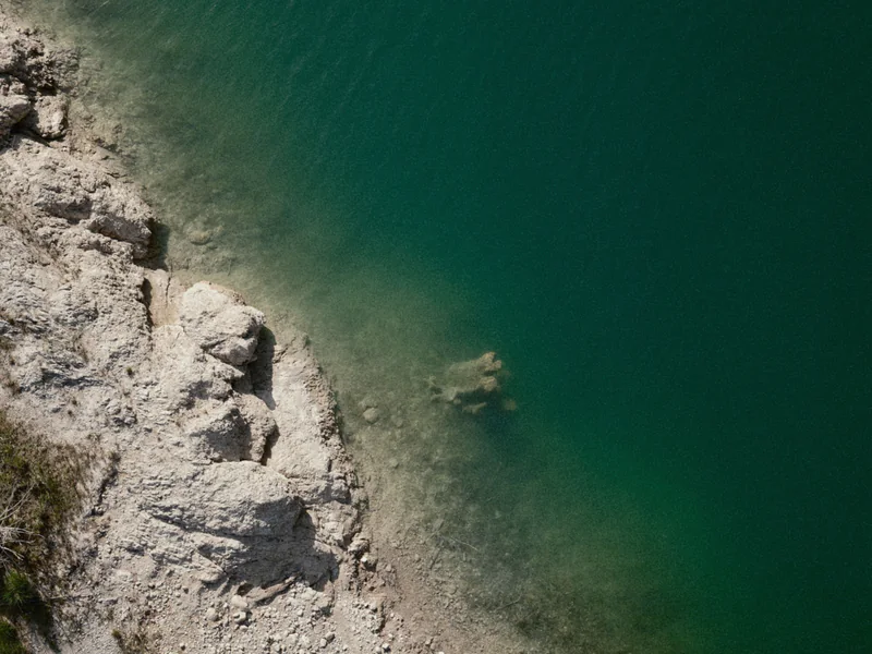 Aerial view of shallow coastal water and rocky seabed with abrupt depth and reflectivity changes
