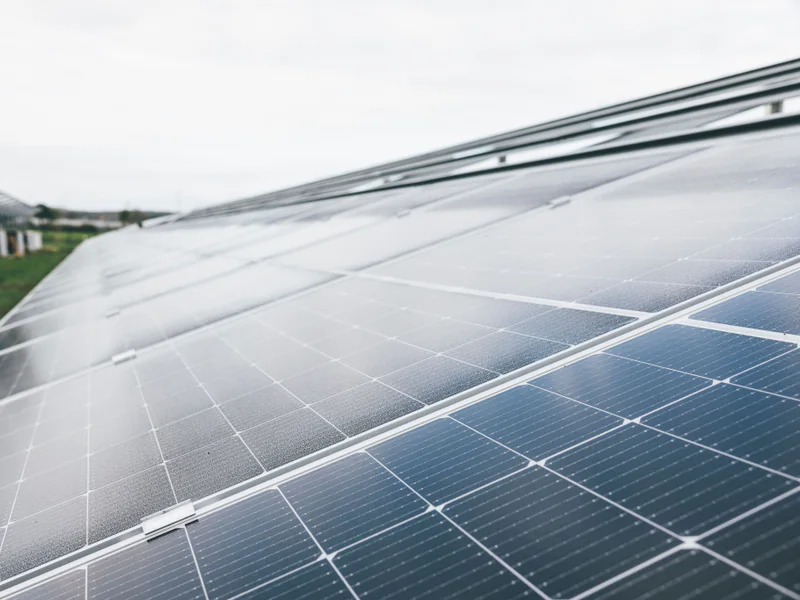 Oblique view of solar module glass reflecting a bright sky