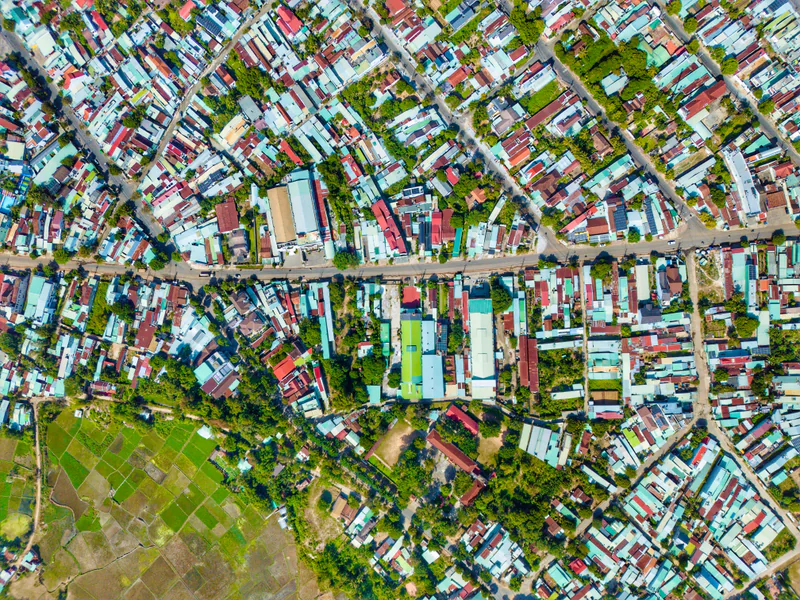 Overhead view of city rooftops and streets with varied shapes and surface textures