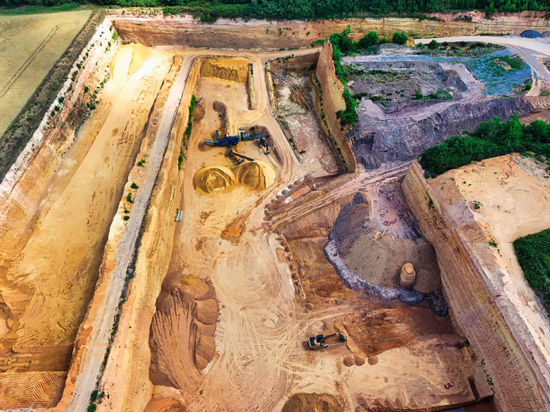 Aerial view of an excavation site with changing elevations and material surfaces