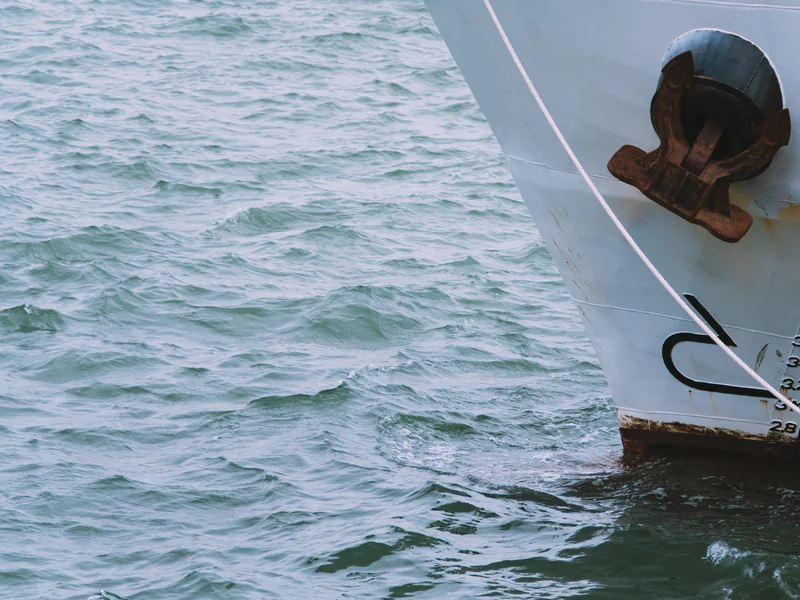 A vessel bow and anchor above the waterline