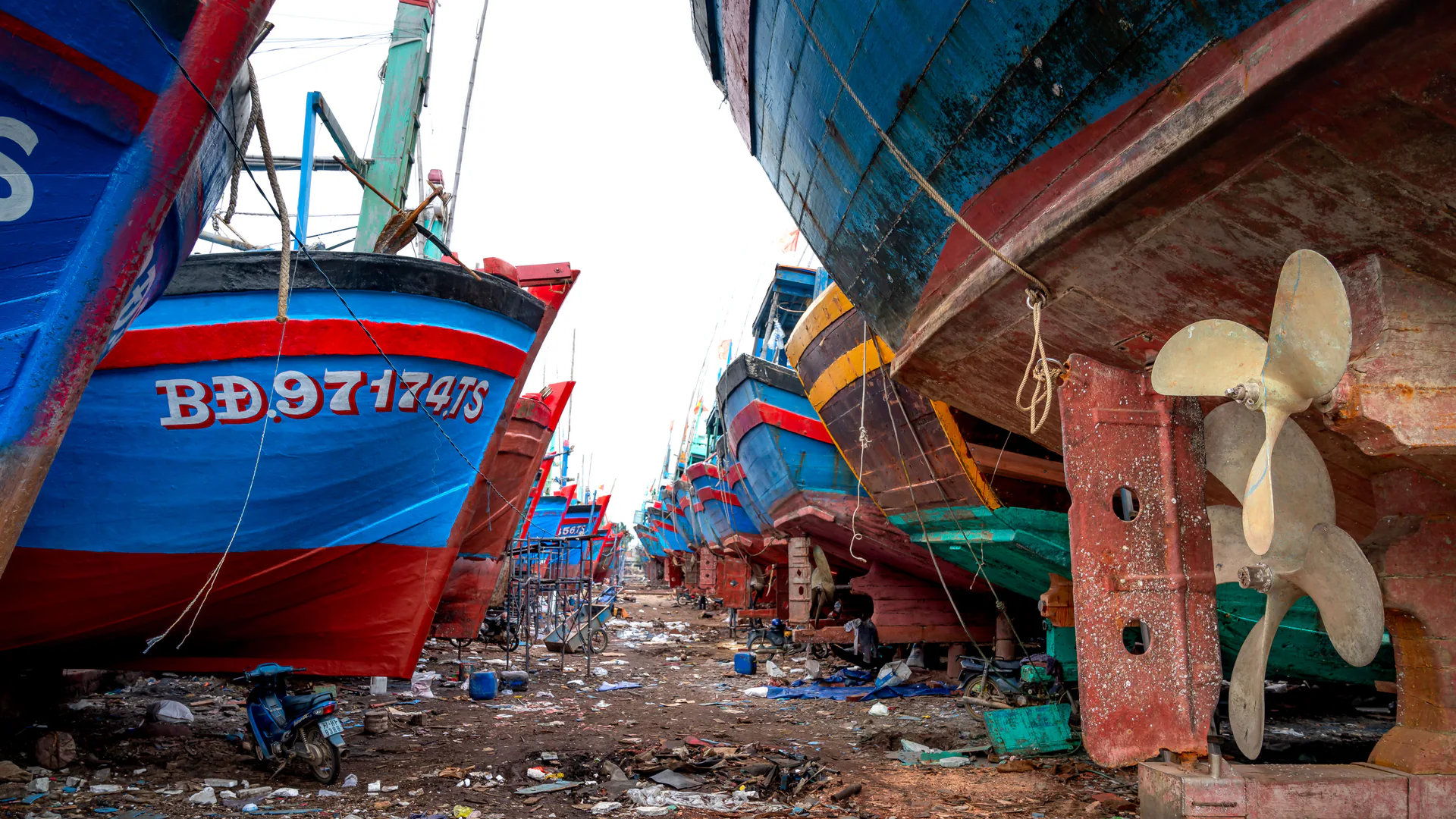 Boat hulls and propellers exposed in a shipyard for maintenance access