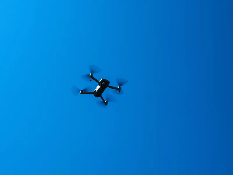Quadcopter in open sky representing the target conditions used to test detection range, tracking and alert latency