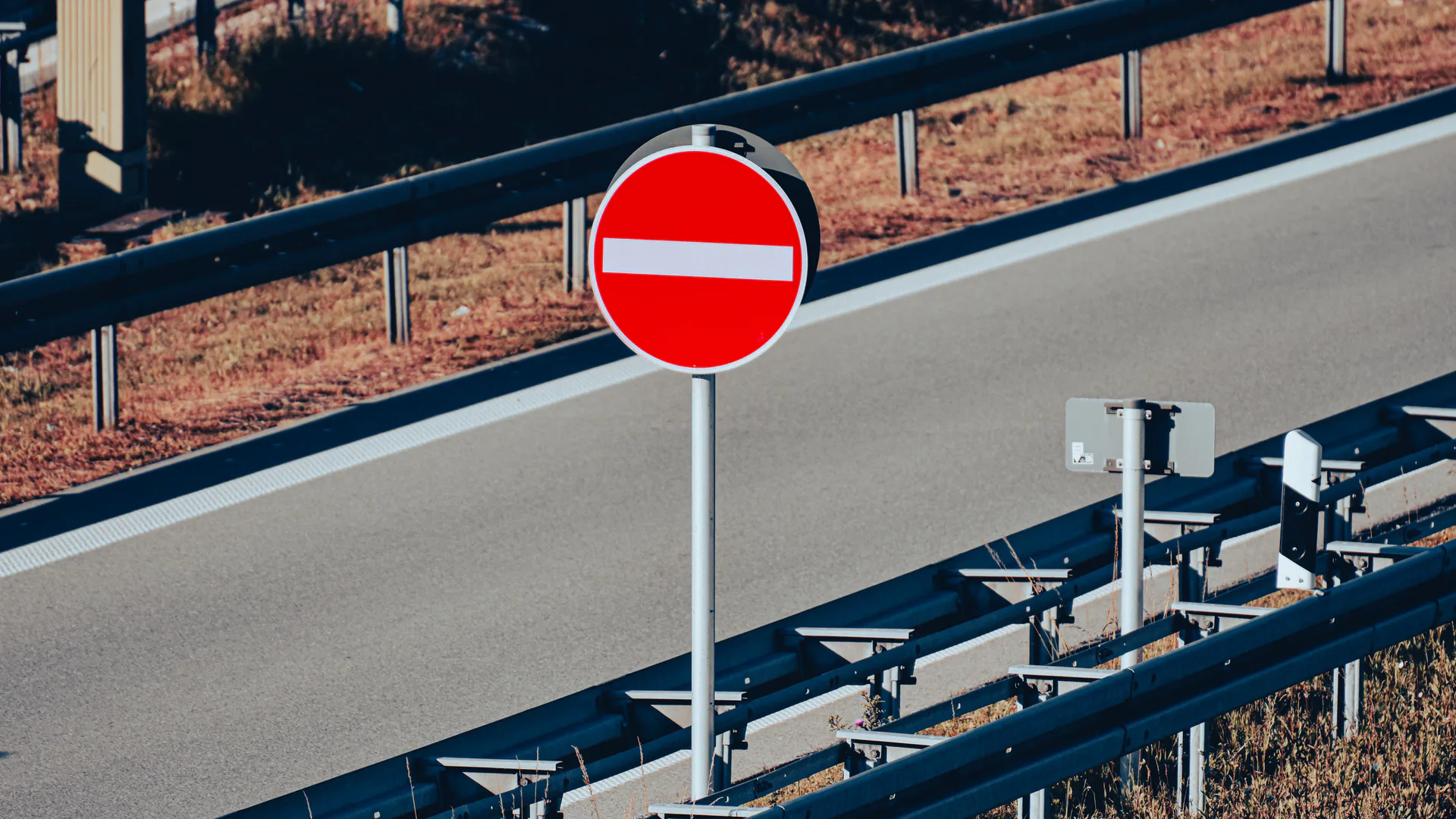Highway entrance ramp where wrong-way detection must distinguish direction before a vehicle reaches the mainline