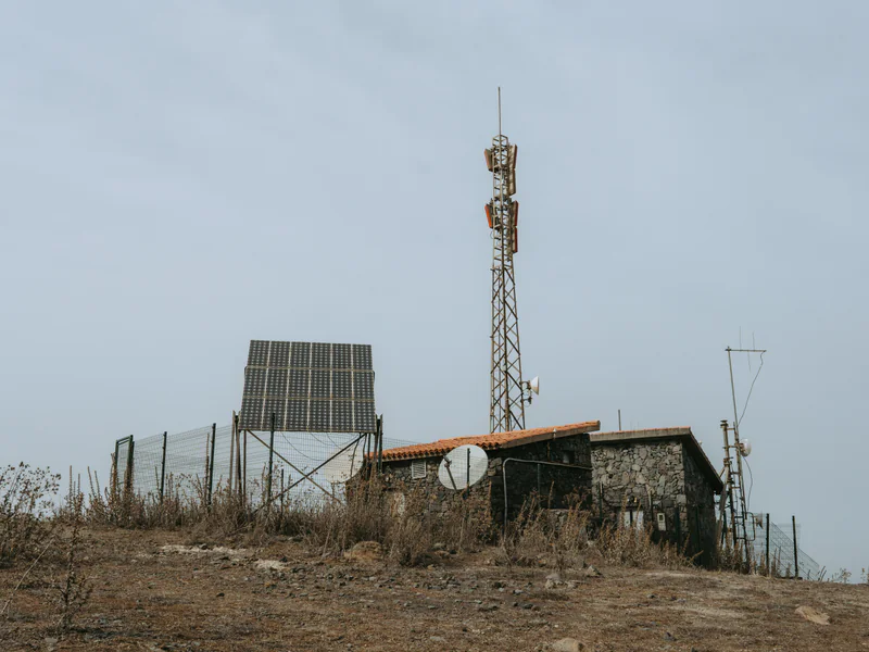 Remote surveillance tower overlooking open terrain that creates line-of-sight and infrastructure constraints